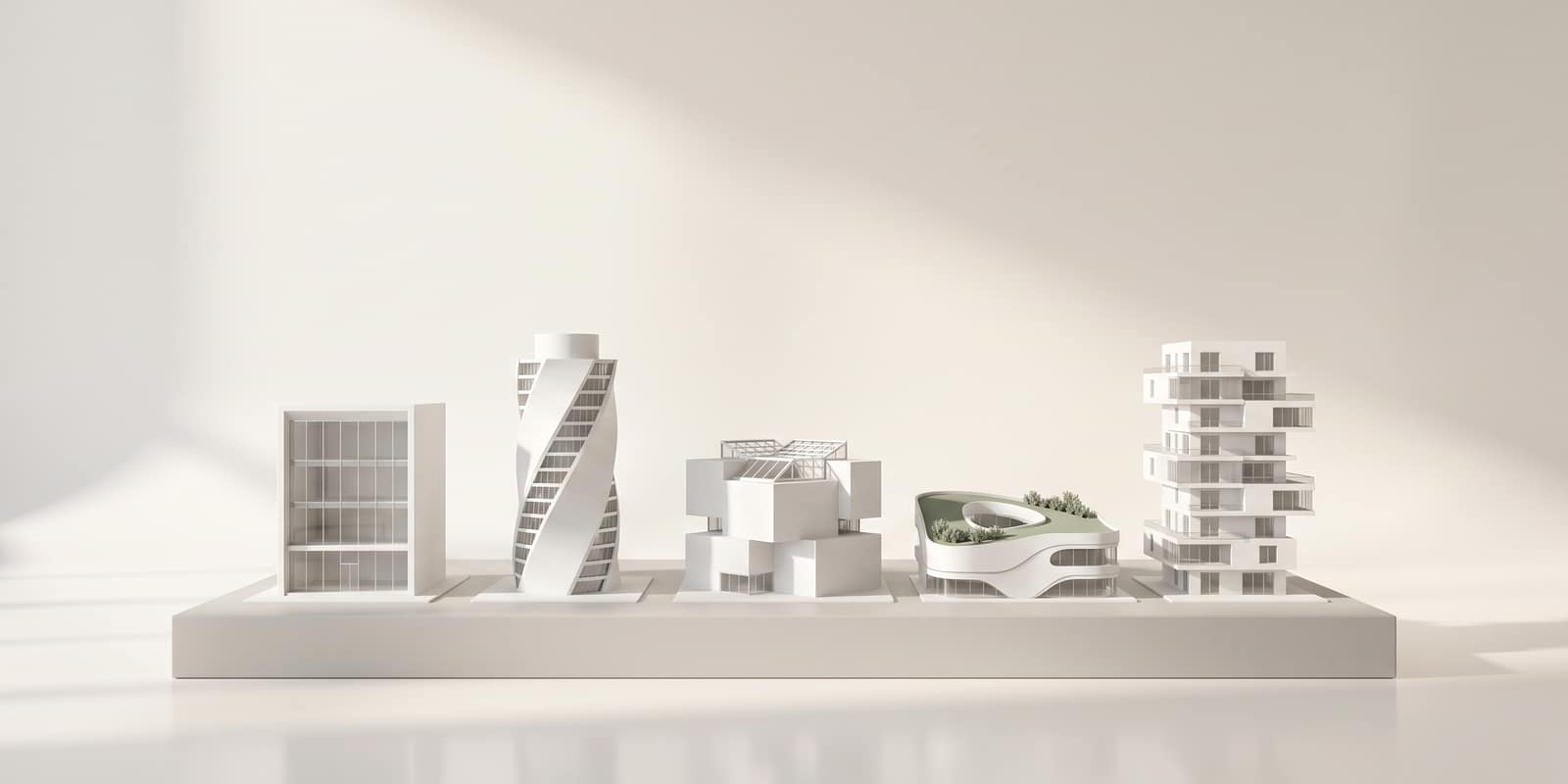A row of five small white architectural models of different modern buildings