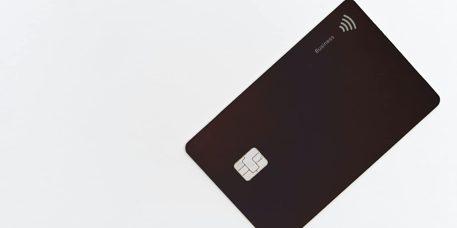 A black payment card with a chip on a white background