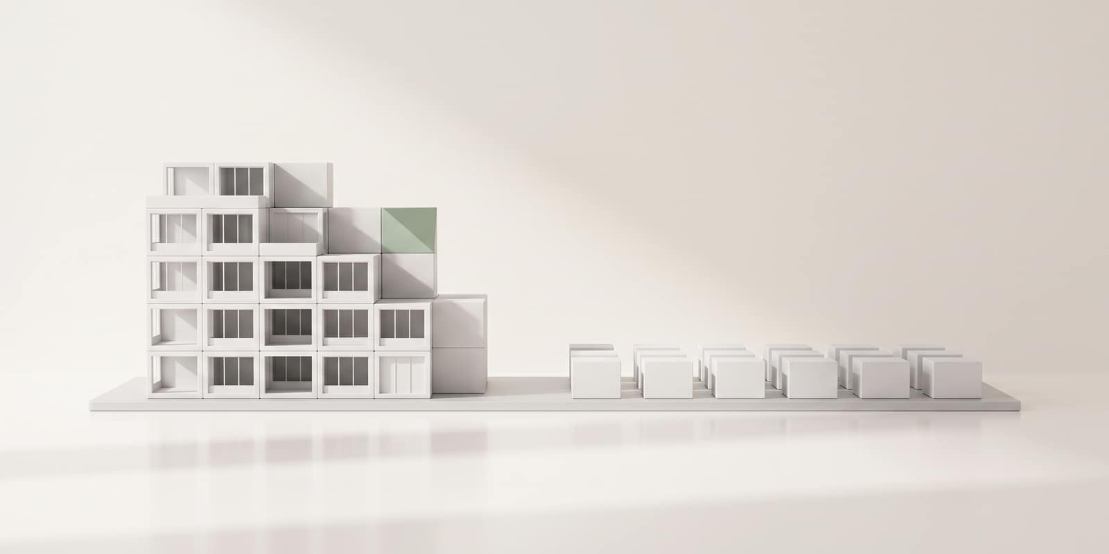 A white model building half reassembled, its remaining blocks laid out in a grid beside it